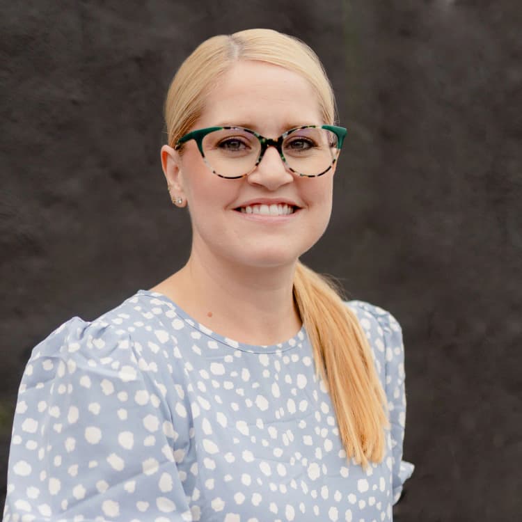 A portrait headshot of a female small business leader in a blue polka dot shirt